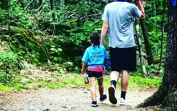 adult and child hiking in woods